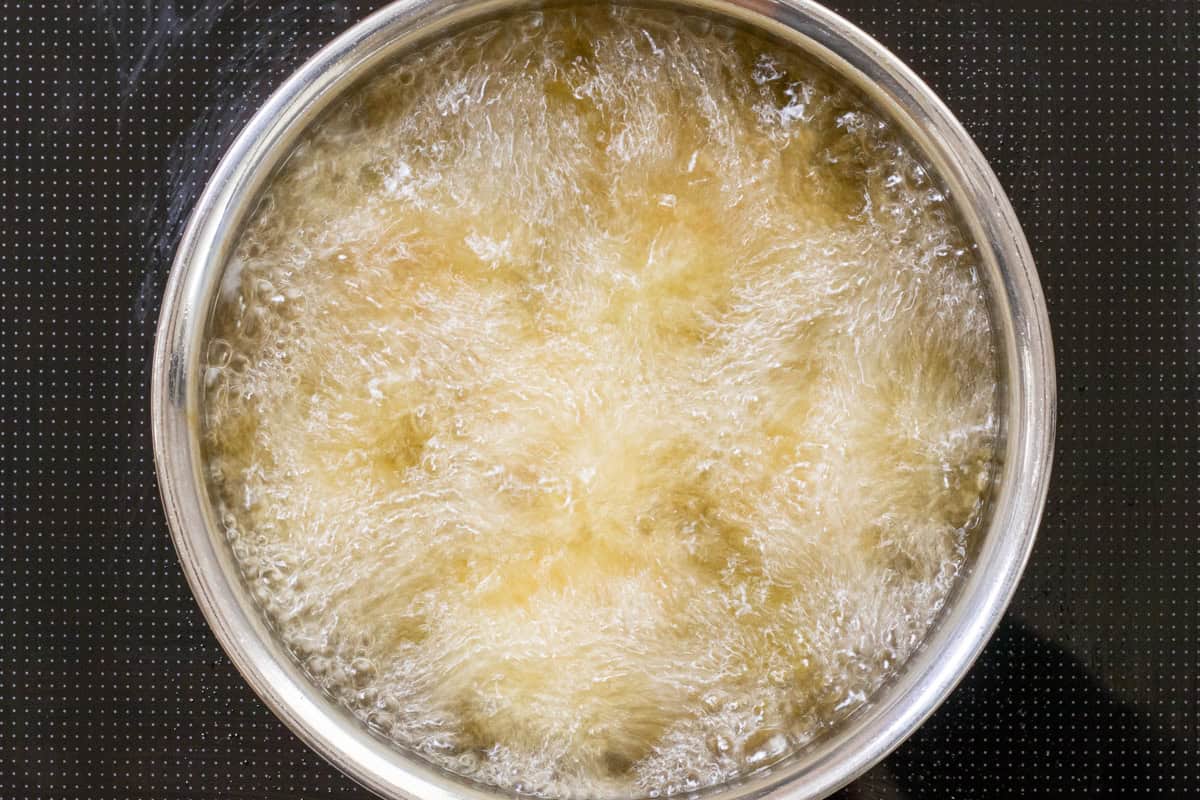 chicken being fried in oil for karaage